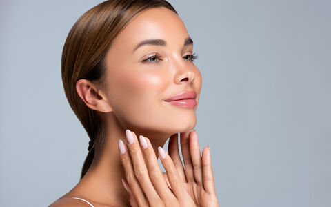Woman with smooth, lifted facial contours, fingertips resting along her jawline