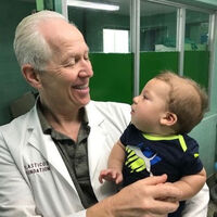 Dr. Nichter holding an infant during a Mission Plasticos mission