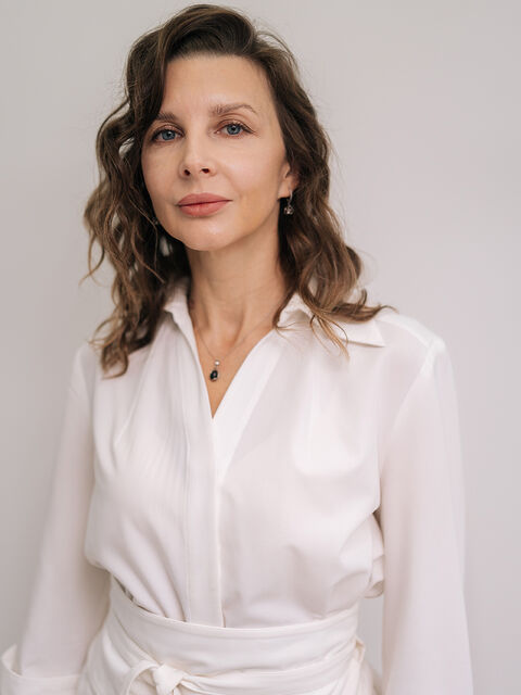 Woman in a white blouse smiling confidently