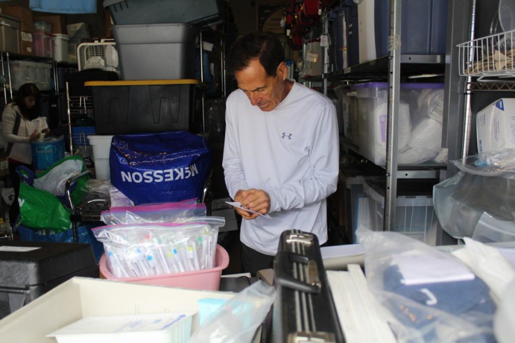 Dr. Bob Burns checks off an extensive list of medical supplies destined for Cuba with the Plasticos team.